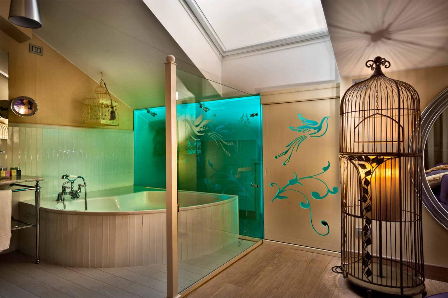 grande jacuzzi nella camera junior suite uccello di fuoco dello chateaux monfort con dettagli in legno e verdi