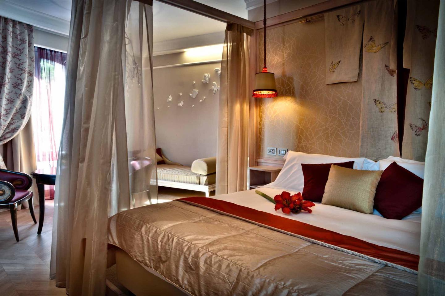 letto della camera junior suite butterfly dello chateaux monfort con dettagli oro e rossi