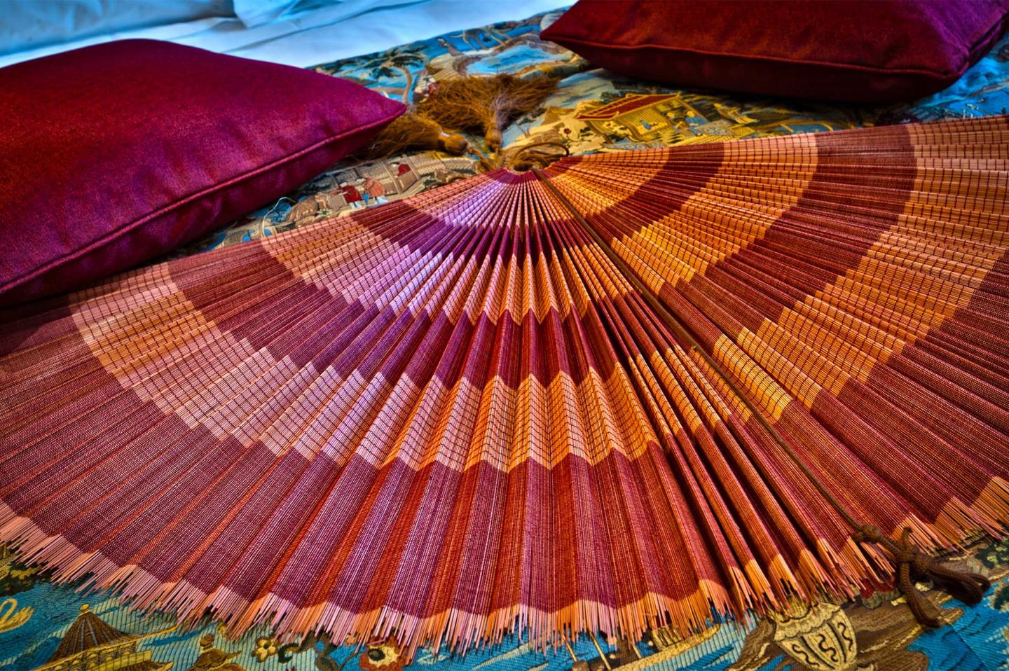 dettaglio decorazione letto con ventaglio rosso nella junior suite turandot all'hotel chateau monfort